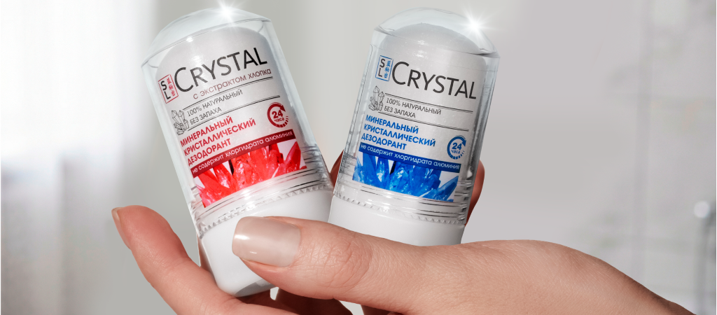 Минеральный дезодорант-кристалл Crystal от Secrets Lan с хлопком и от сильного запаха пота в виде стика в руке девушки